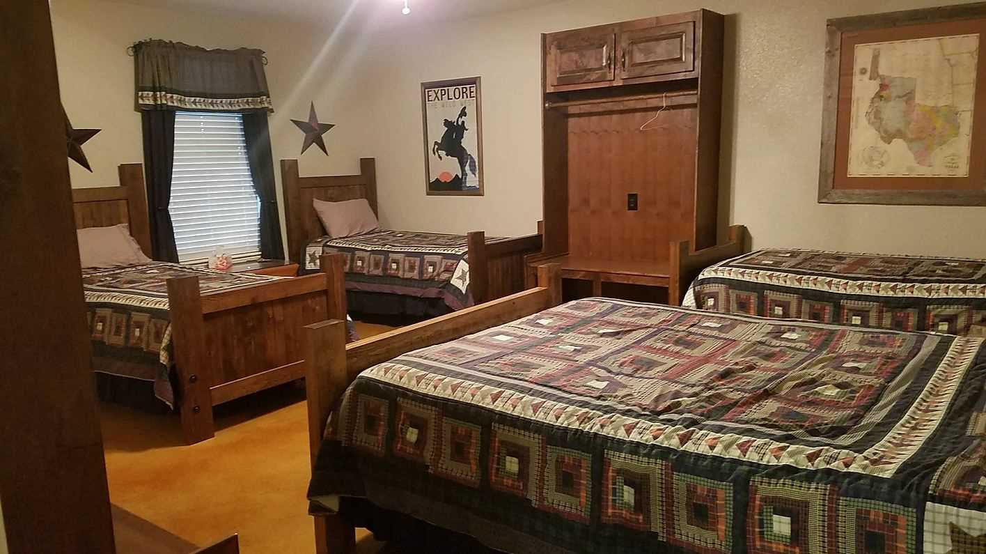                                                 The first bedroom features fun Texas touches, as well as a roomy queen and three twin beds.