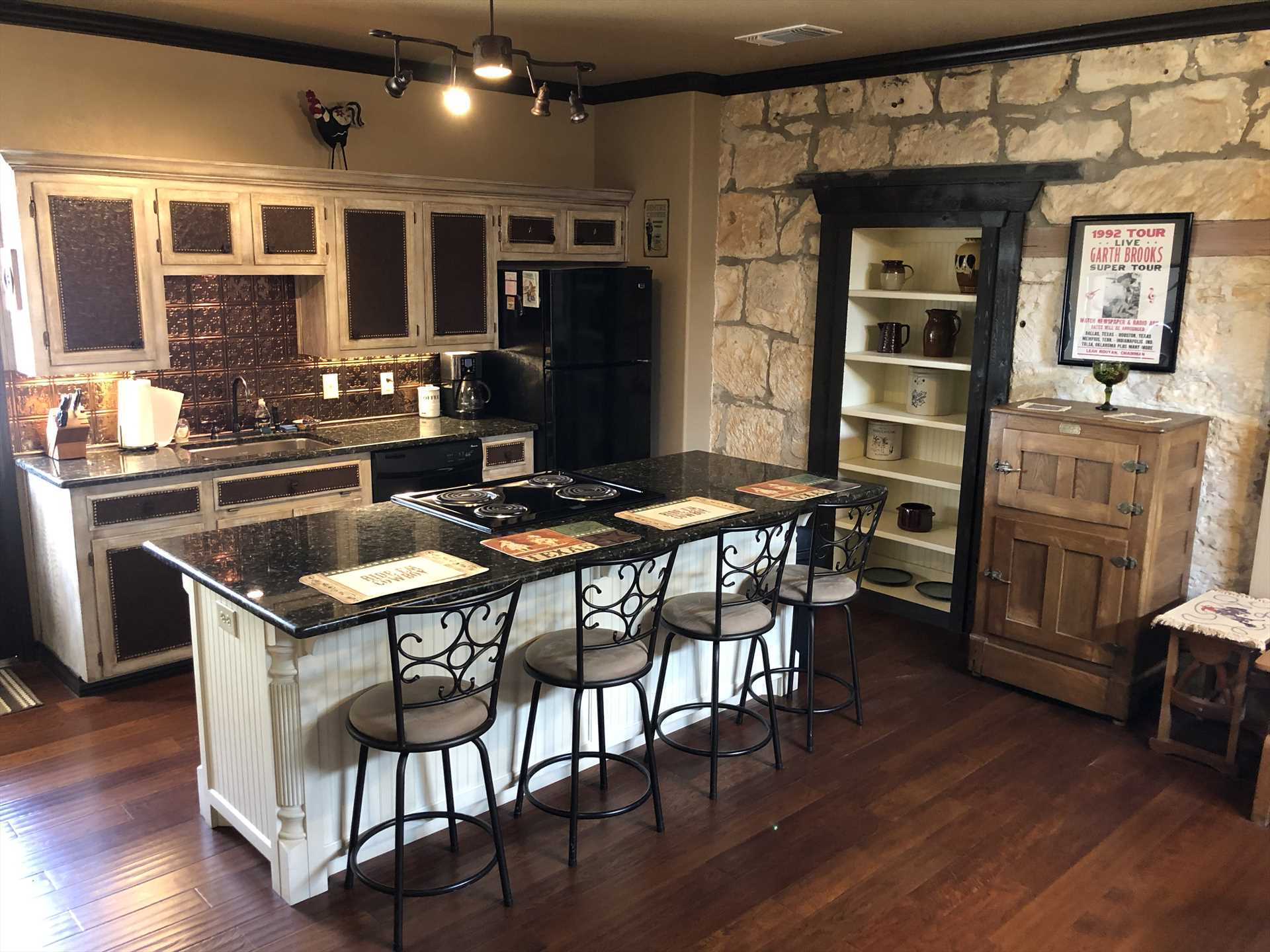                                                 The full kitchen features not only modern appliances, but all the cooking ware, utensils, glasses, and serving ware you'll need. There's also a sweet-looking bar area with seating for four!