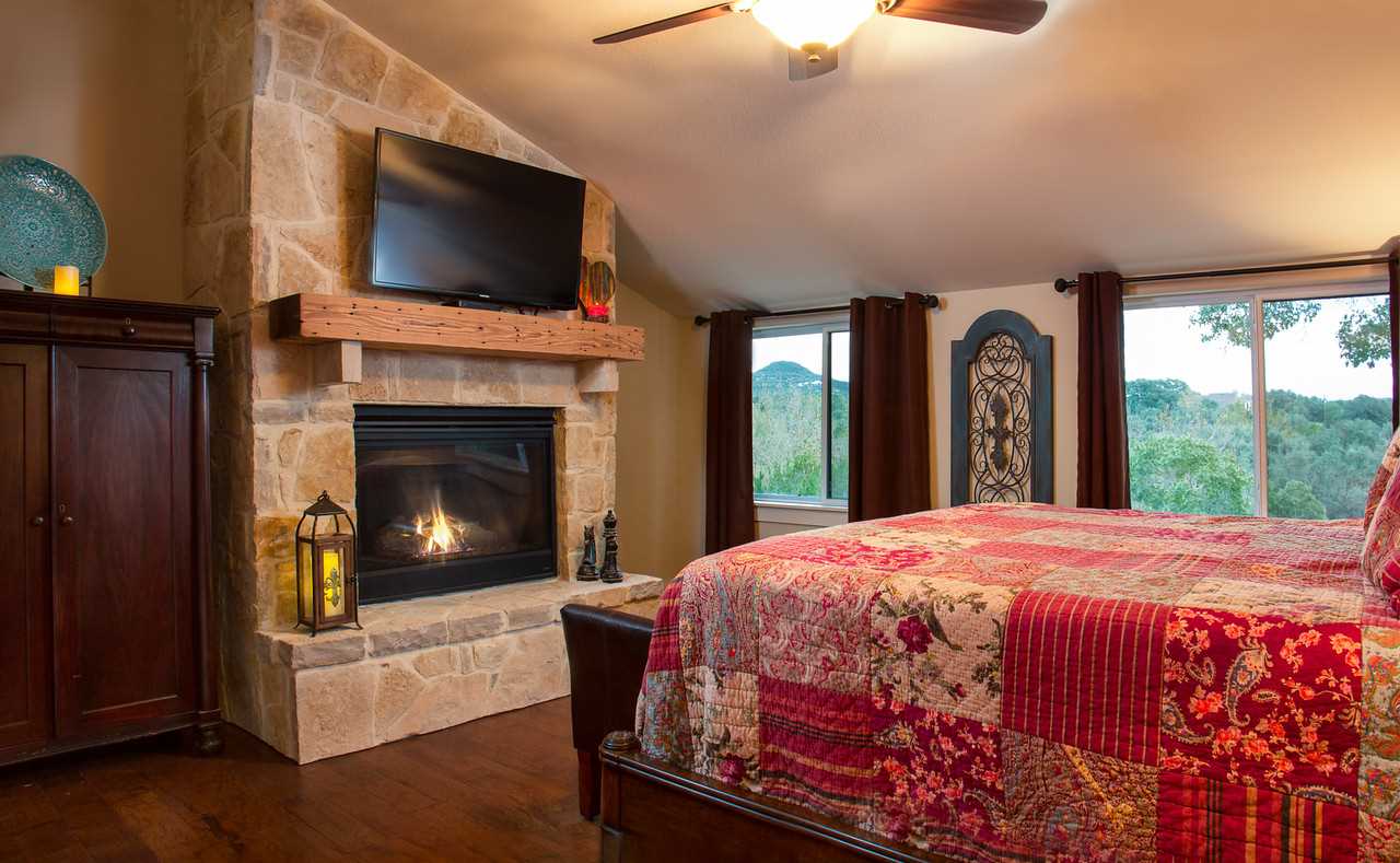                                                 Satellite TV and a toasty fireplace share space with a roomy and comfortable king-sized bed in the master bedroom. All beds in the Barndominium come with clean and soft linens.
