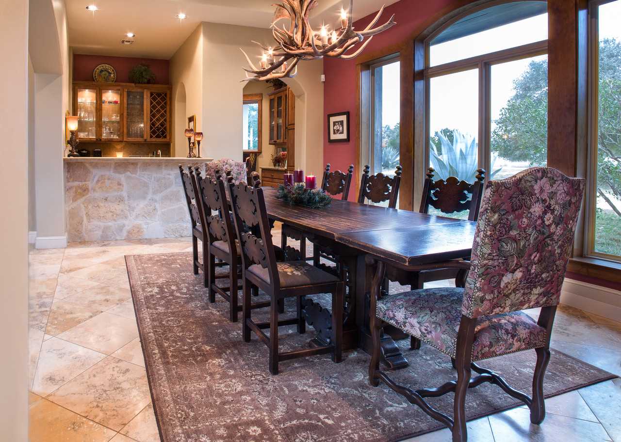                                                 Natural light and an antler chandelier create a wonderful dining experience around a table fit for a castle!