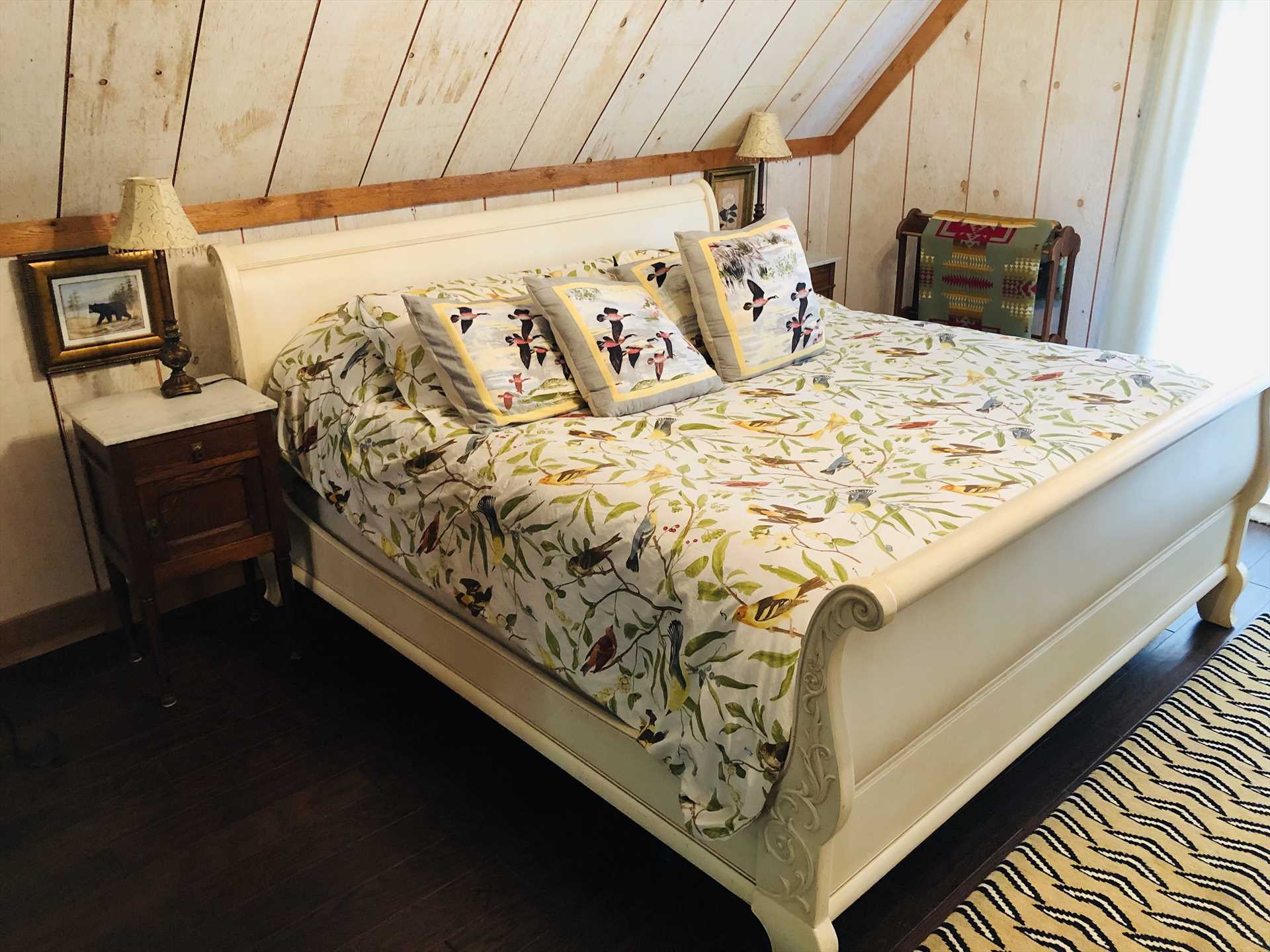                                                 The vintage sleigh-style bed is fully dressed with soft, quality linens and throw pillows.