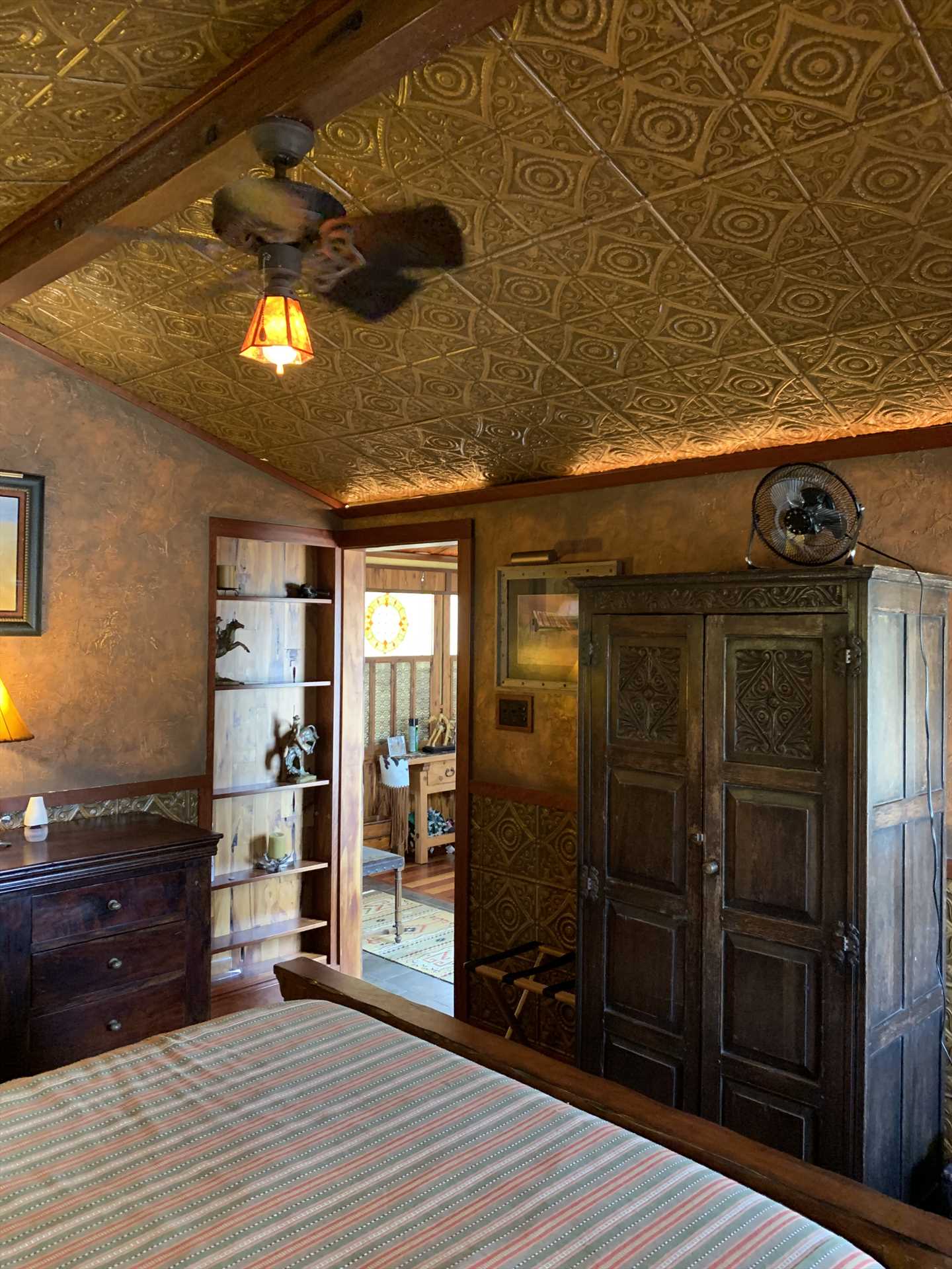                                                 The delightful vintage decor continues in the bedroom, which is accented by charming tin panels and a beamed ceiling!