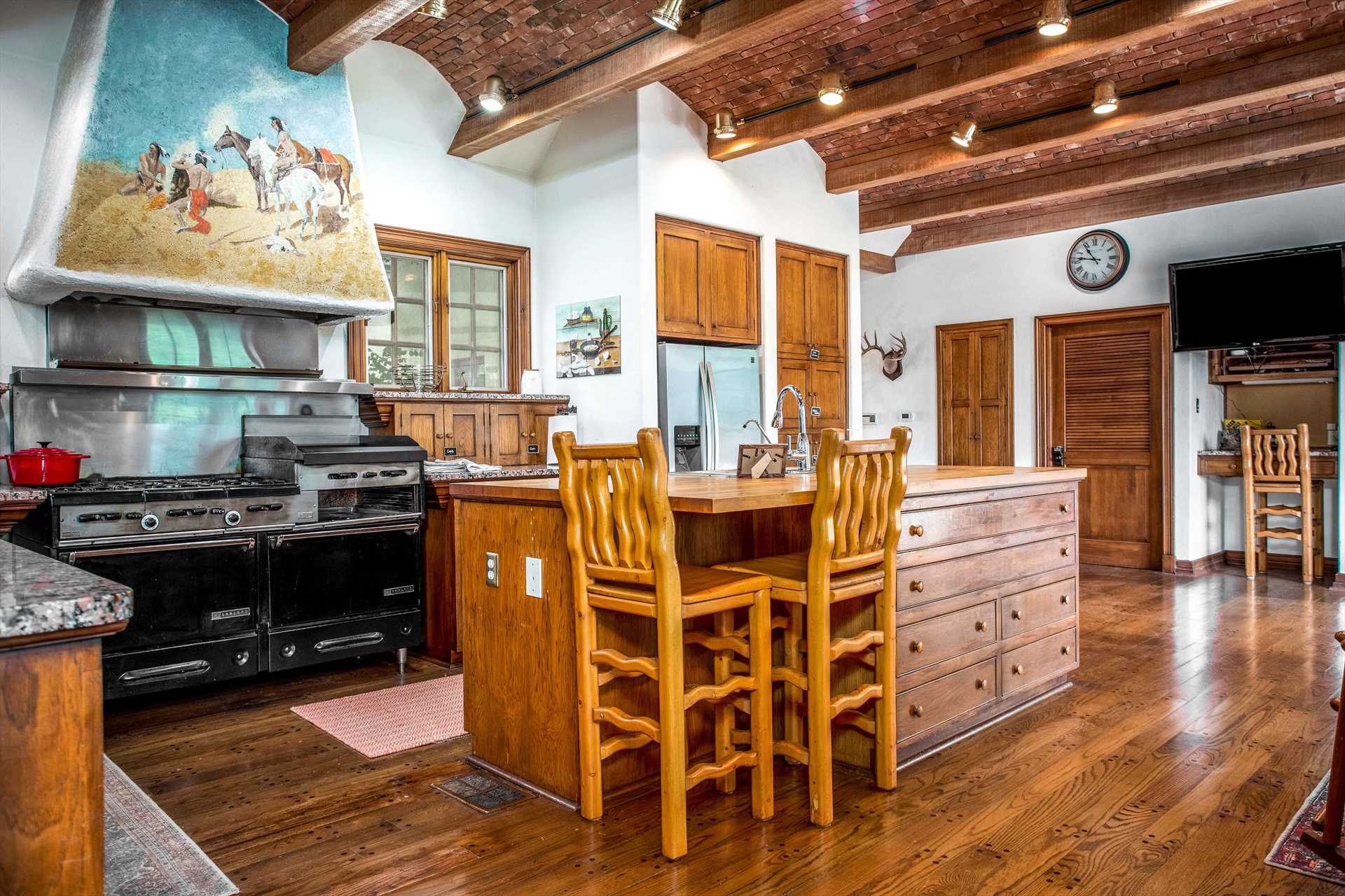                                                 A commercial-grade oven and stove top are crowned by a beautiful southwestern mural and grand and stately beamed ceilings!