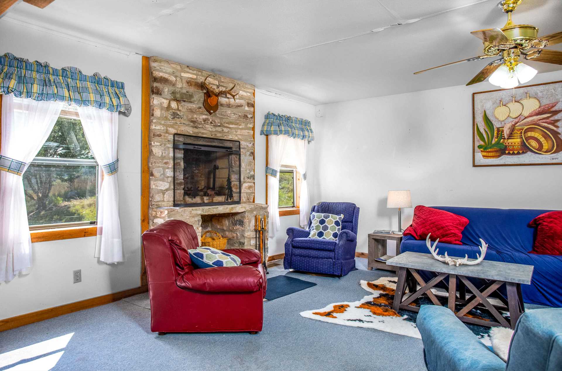                                                 Country gingham, a warm fireplace, and comfortable furnishings all add up to a relaxing and homey living space in the Hill House!