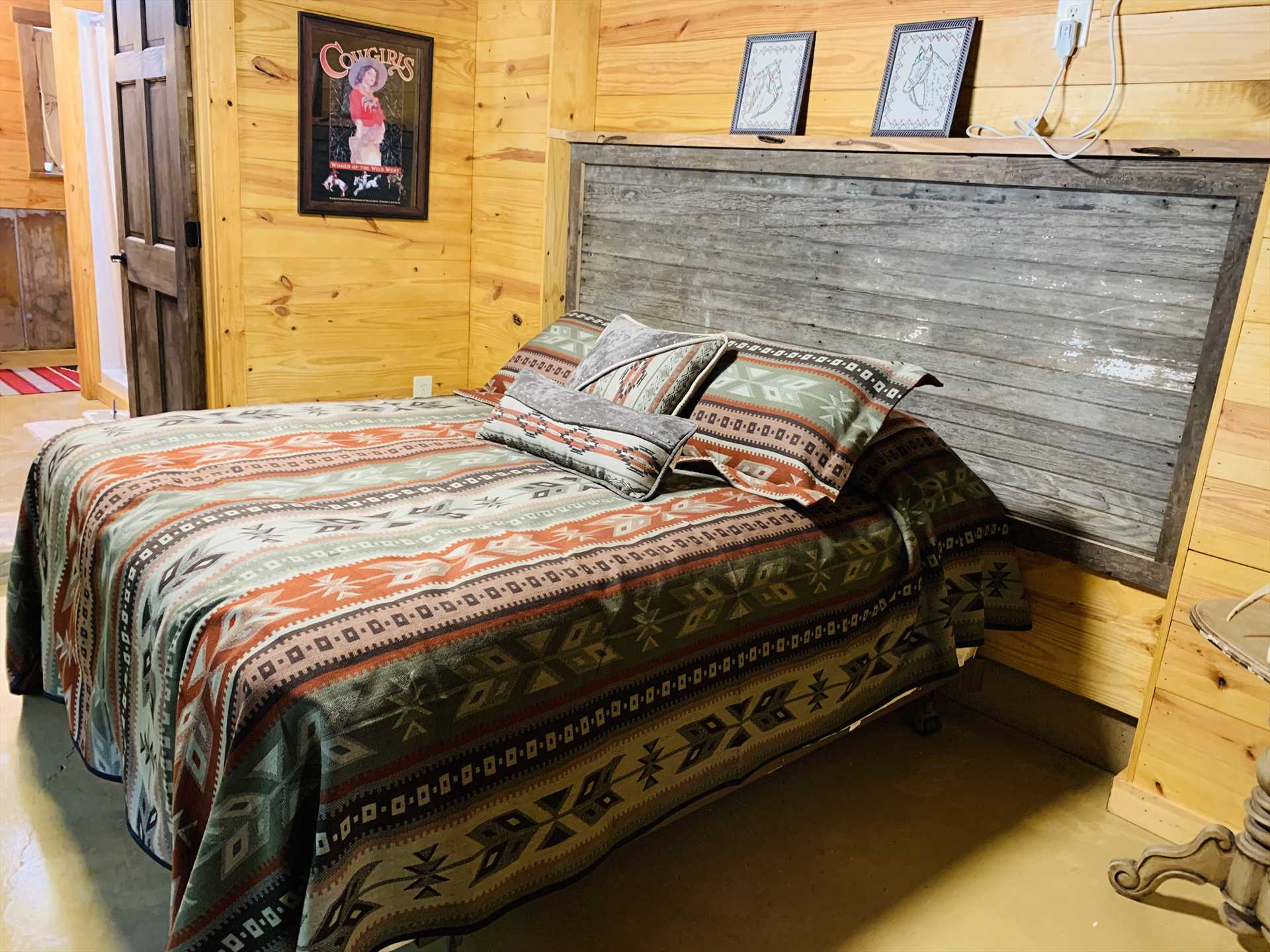                                                 The plush queen-sized bed comes with soft and comfy linens-and check out that barn board headboard!
