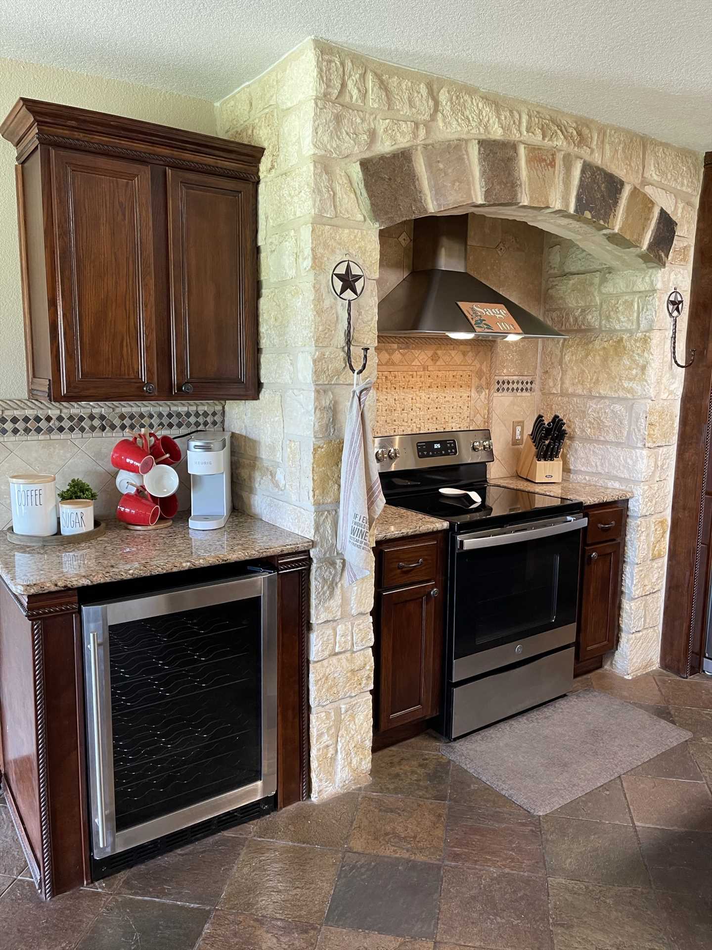                                                 The well-appointed kitchen features not only modern appliances, but pretty and functional wood and stone highlights.