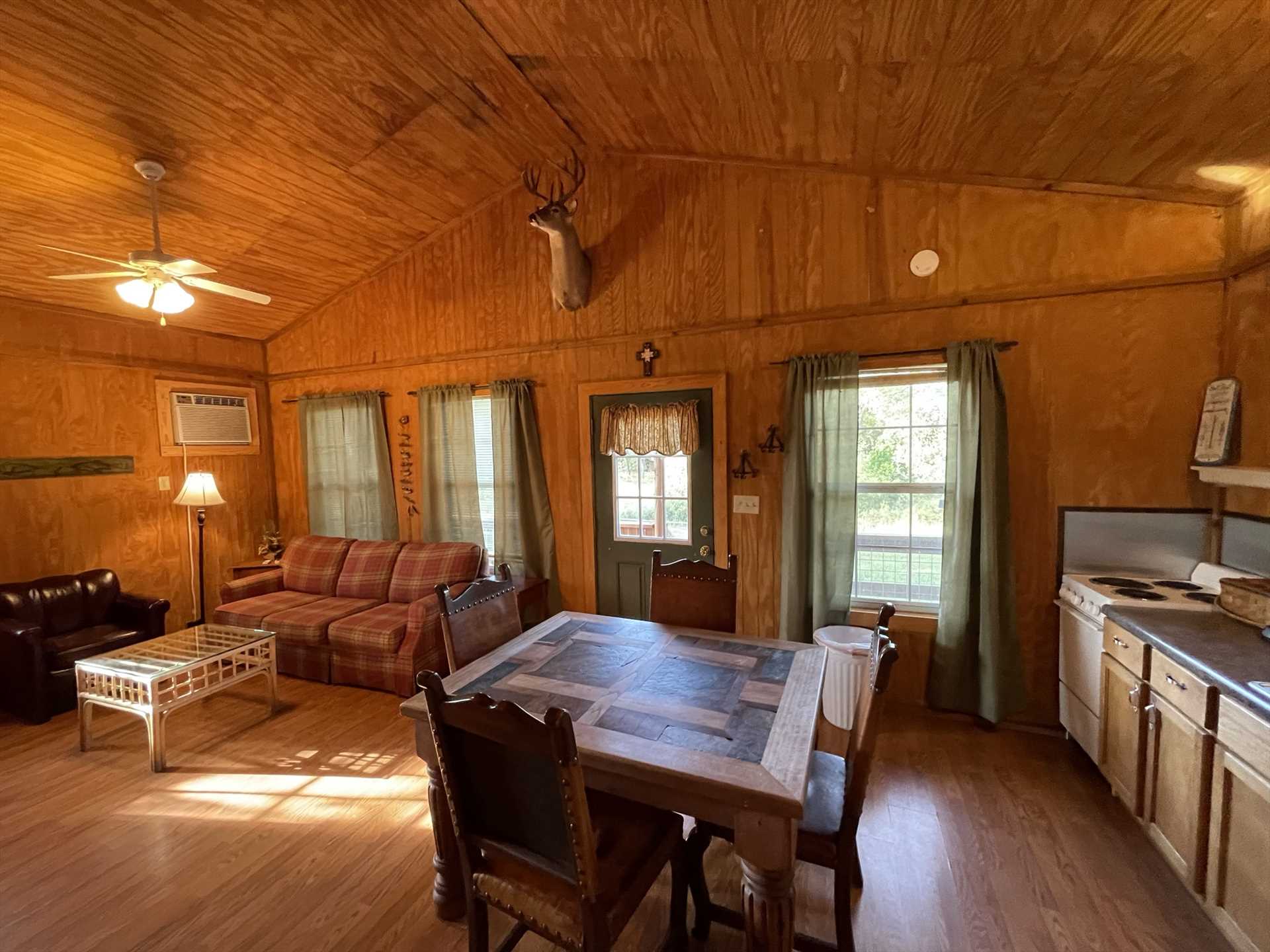                                                 The wide-open floor plan of the Gone Fishin' Cabin includes a fully-stocked kitchen, dining area, and roomy and inviting living space.