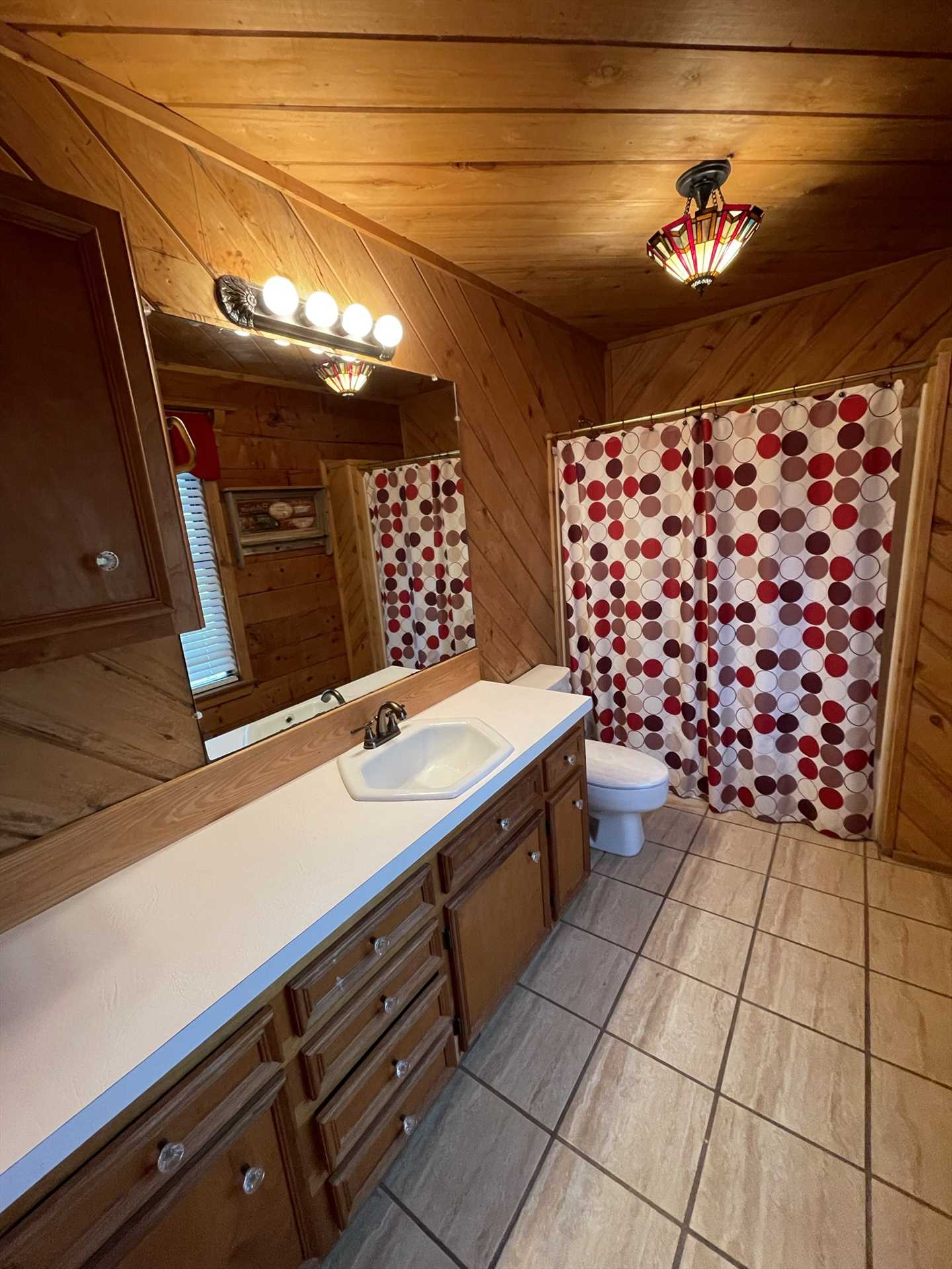                                                The master bath in the Lodge is roomy and neat as a pin, with a tub and shower combo for easy cleanup.
