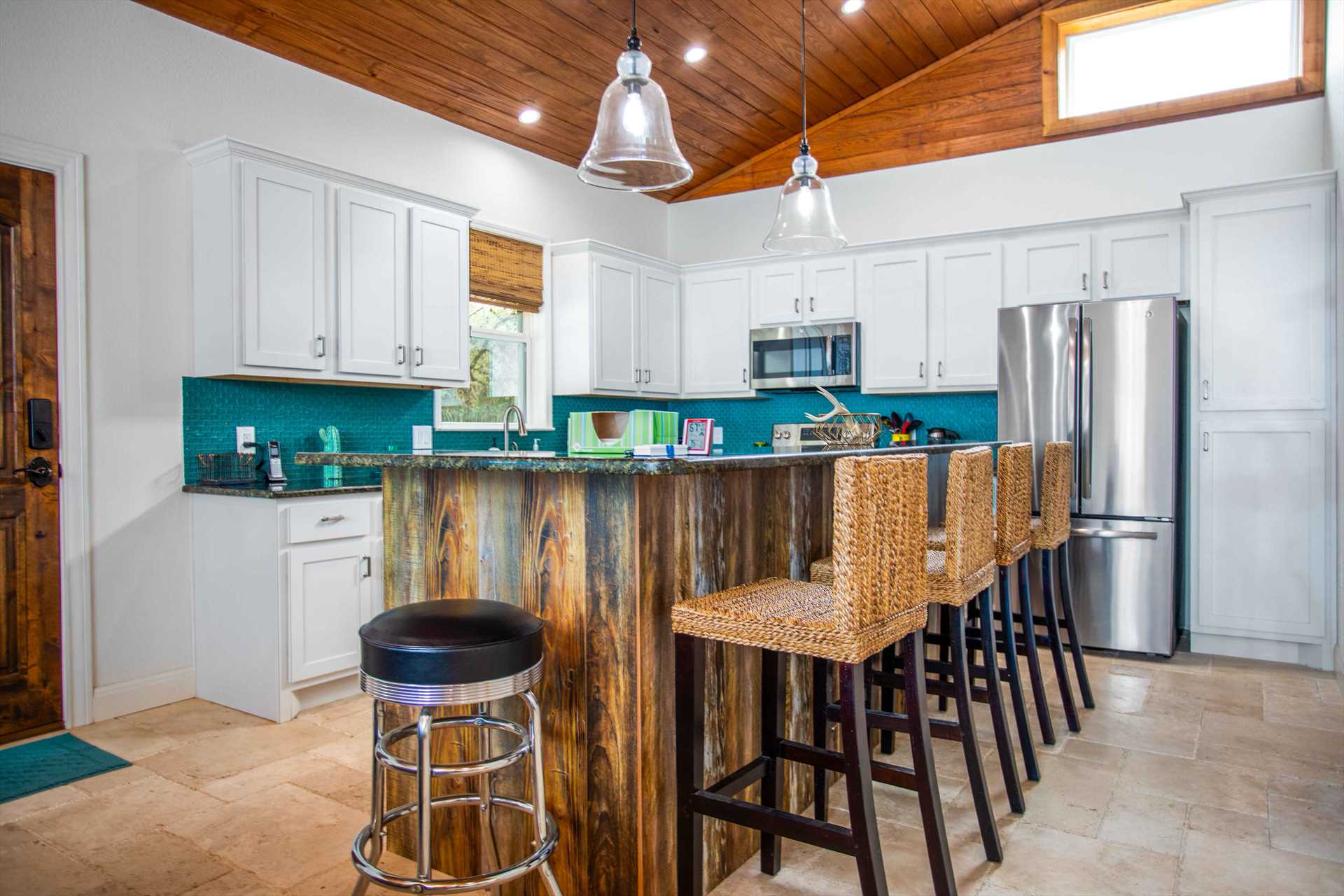                                                 Bar-style seating around the kitchen island provides a casual spot for mealtimes!