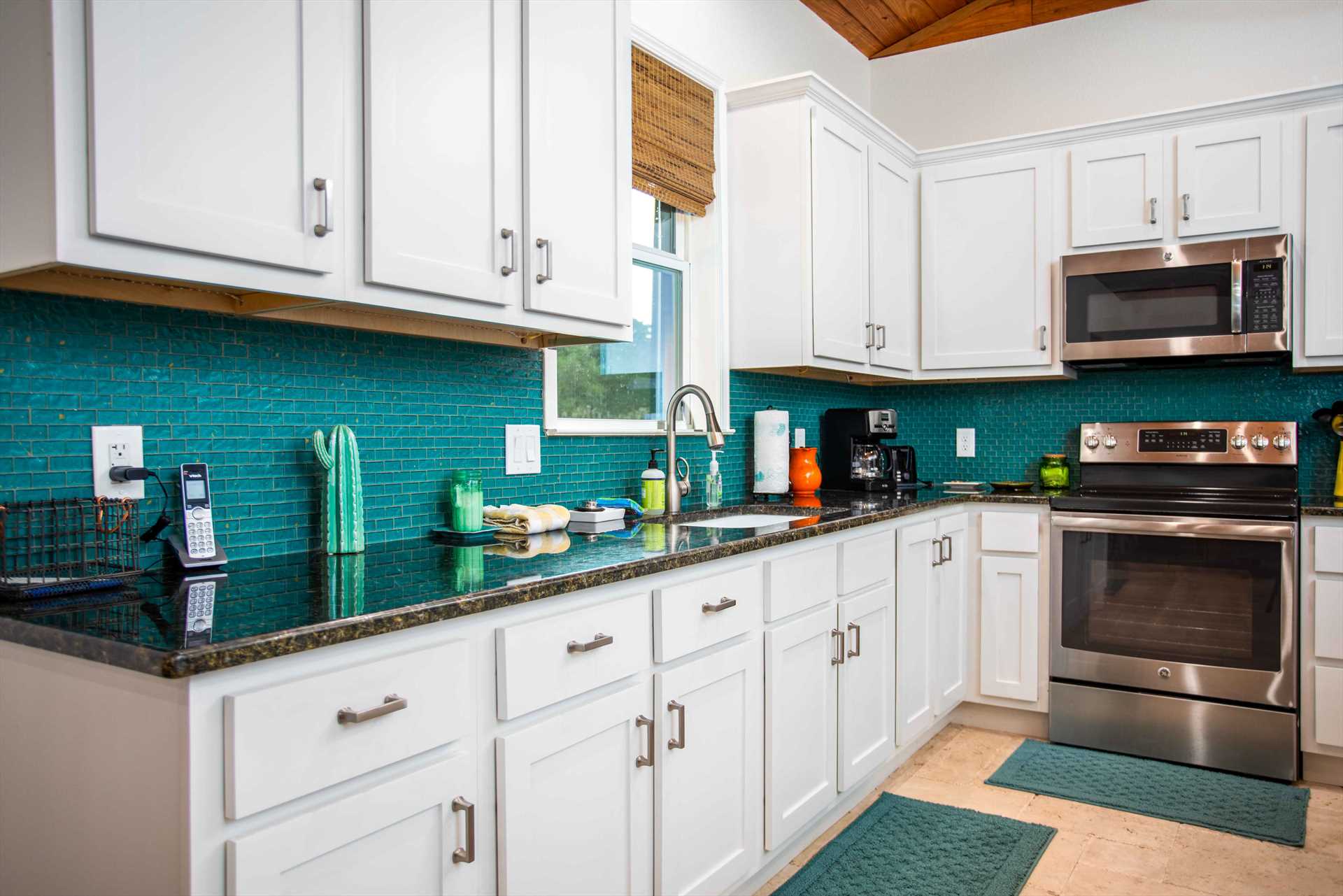                                                 The full kitchen features modern appliances and plenty of cooking ware, serving, ware, utensils, and even spices!