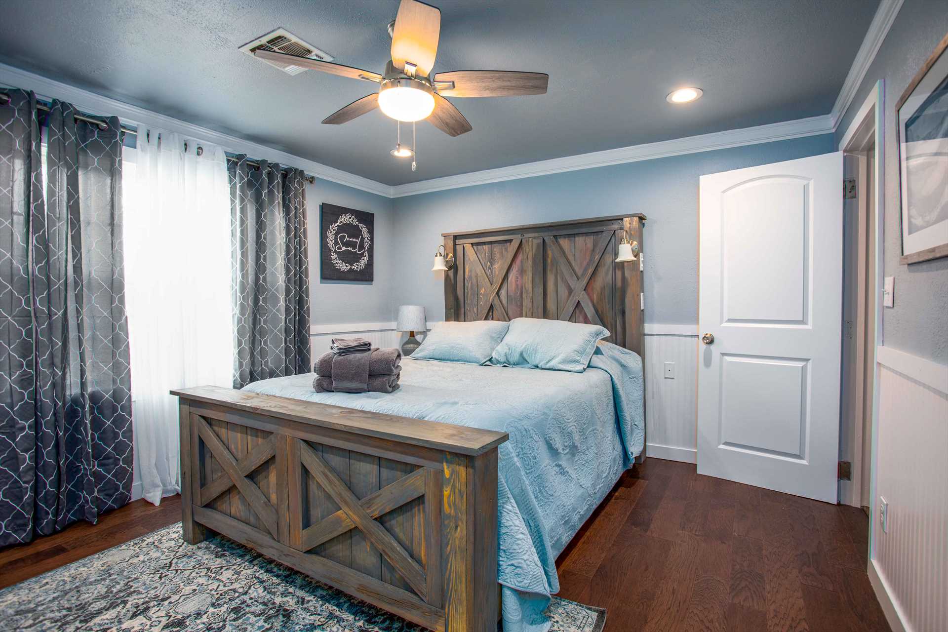                                                 Barn door head and foot boards on the comfy queen bed in the master bedroom add to the country touches throughout the house.