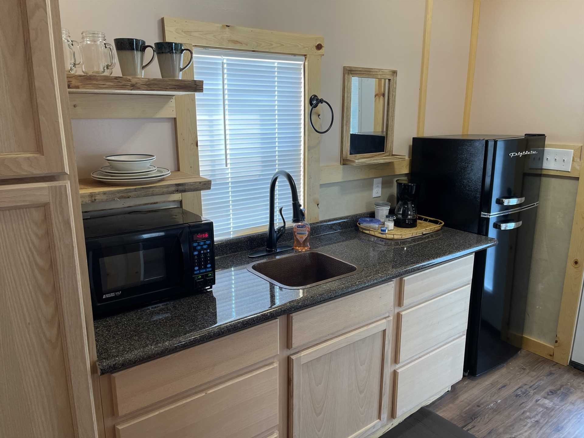                                                 You'll have a stylish and functional kitchen here, with a fridge, microwave, coffee machine, and serving ware!