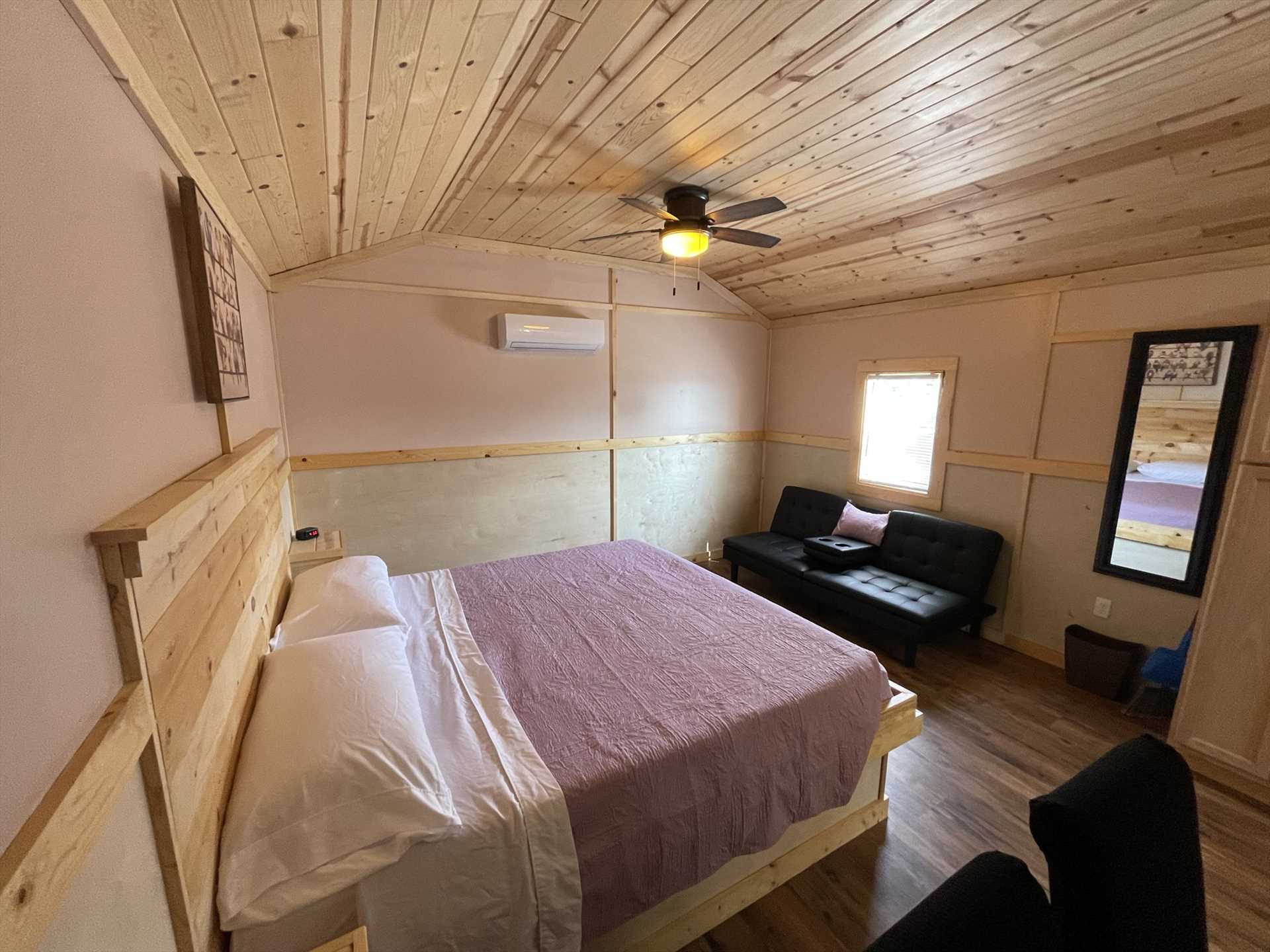                                                 A plush king-sized bed, futon, and bar-style chairs will all help you relax. The cabin sleeps three, and comes with clean bed linens, too!